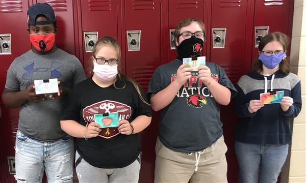 Students stand in front of locker